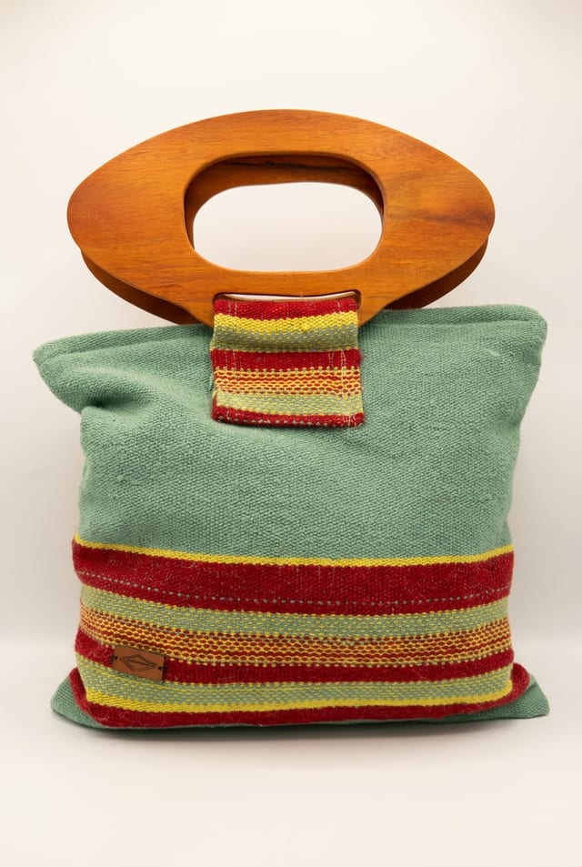Cartera de lana de oveja verde pastel con franjas rojas y asas de madera